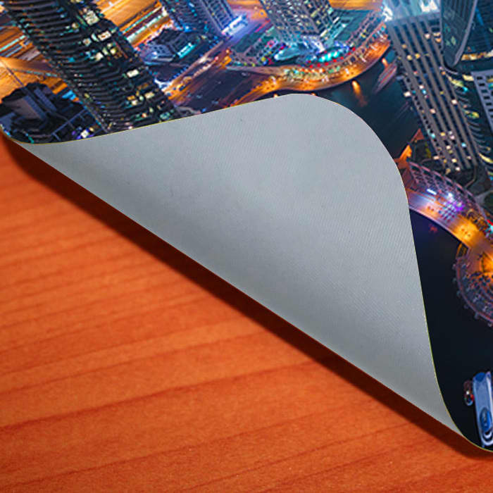 A grey gripper repositional mouse mat featuring a vibrant cityscape design on its surface.