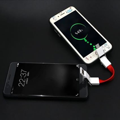 A 4 in 1 USB charging cable in red, connecting two smartphones, with one device displaying a charging status.