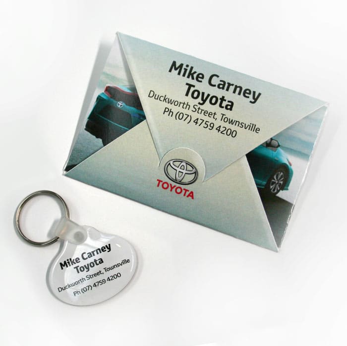 A key tag and a grey presentation folder featuring a logo and an image of a car.