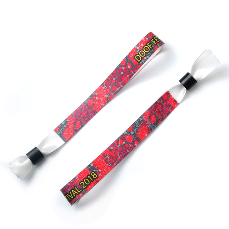 A red fabric wristband featuring a patterned design and with a black fastening. It includes a logo.