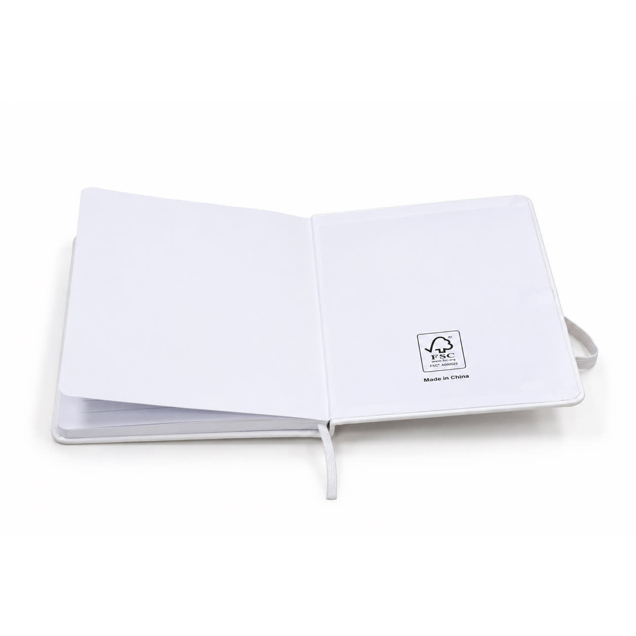 A white FSC notebook with blank pages and a logo on the inside cover, featuring a ribbon bookmark.