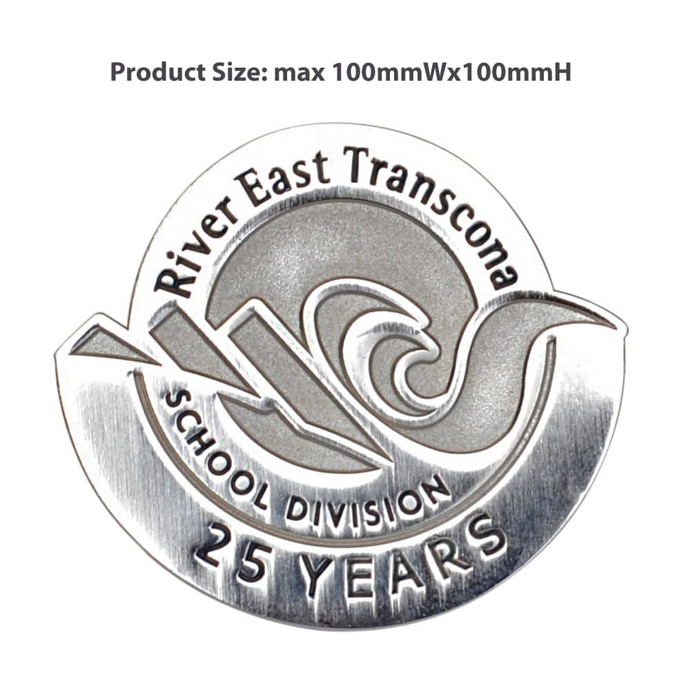 A silver die struck lapel pin featuring a wave design and text indicating "25 Years". It includes a logo and is circular.