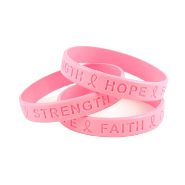 Three pink debossed silicone wristbands featuring words like "Strength," "Hope," and "Faith." Each band has a logo.