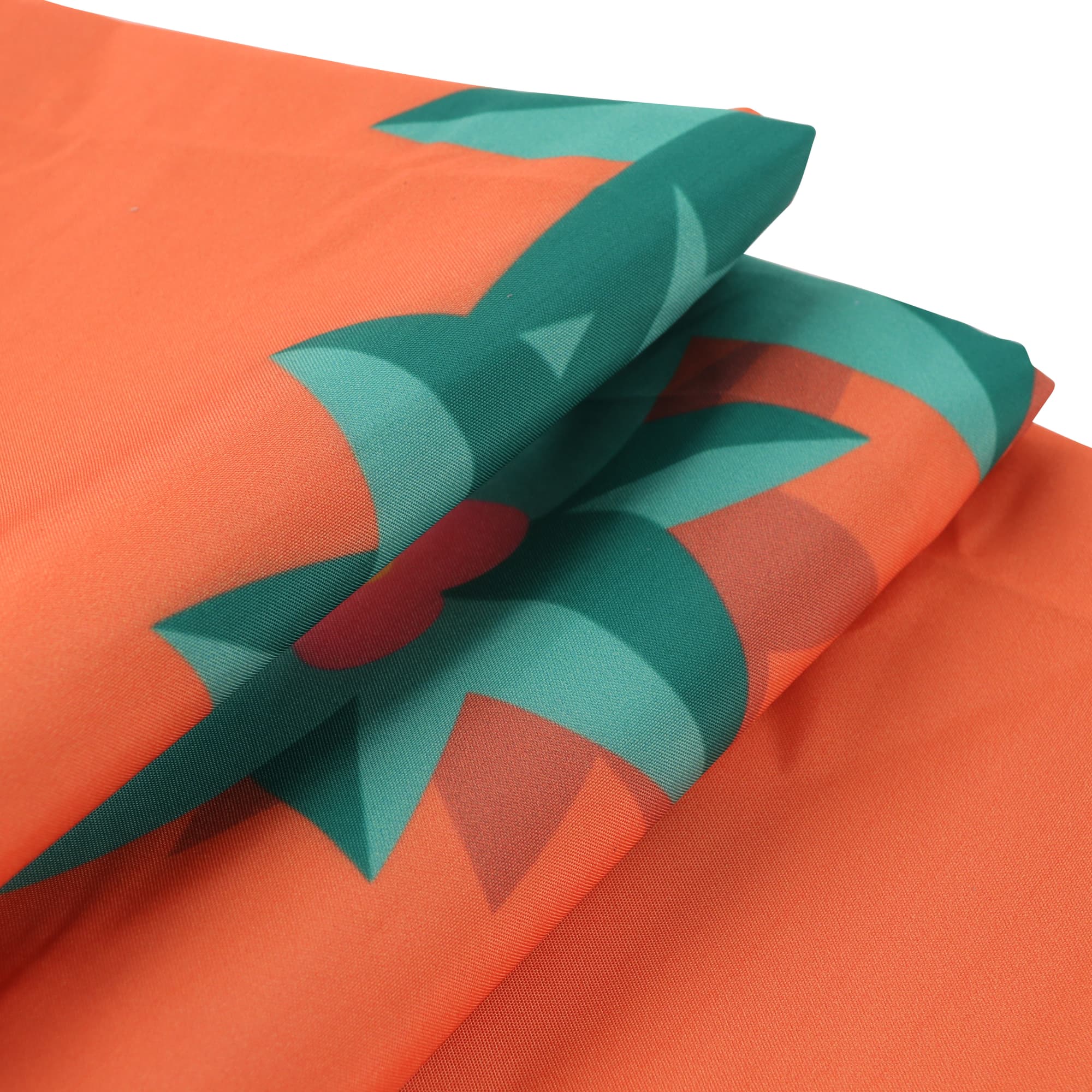 An orange picnic blanket with green floral patterns, showcasing its folded design. It has a branding logo.