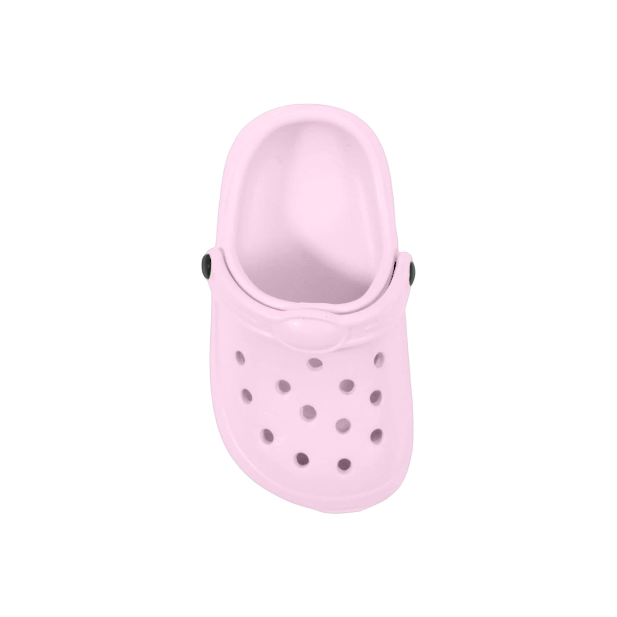 A pink clog shoe-shaped charm with ventilation holes and decorative buttons. It features a simple design and has a smooth finish.