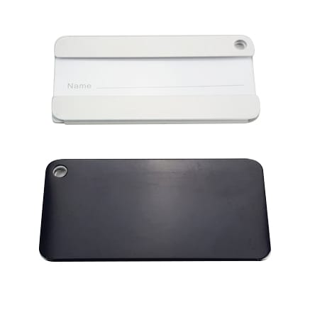 A square aluminium luggage tag in black and white, featuring a hole for attachment and a blank name section.