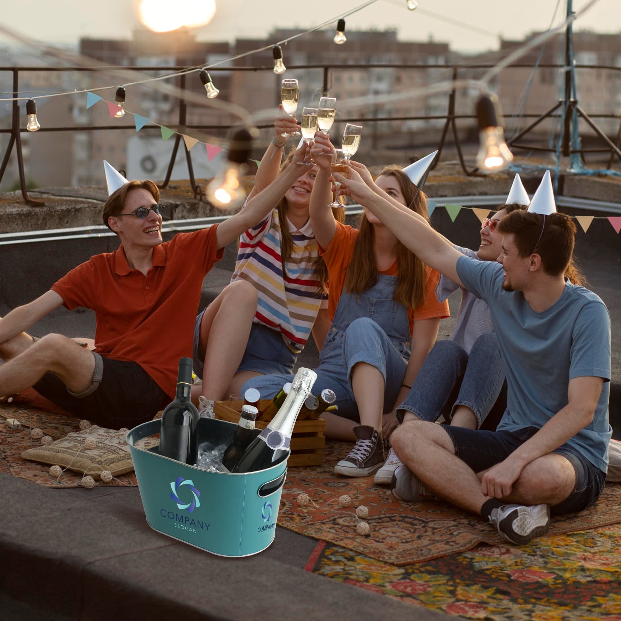An oval ice bucket in a light blue colour, surrounded by drinks, with five people celebrating. A logo is visible.