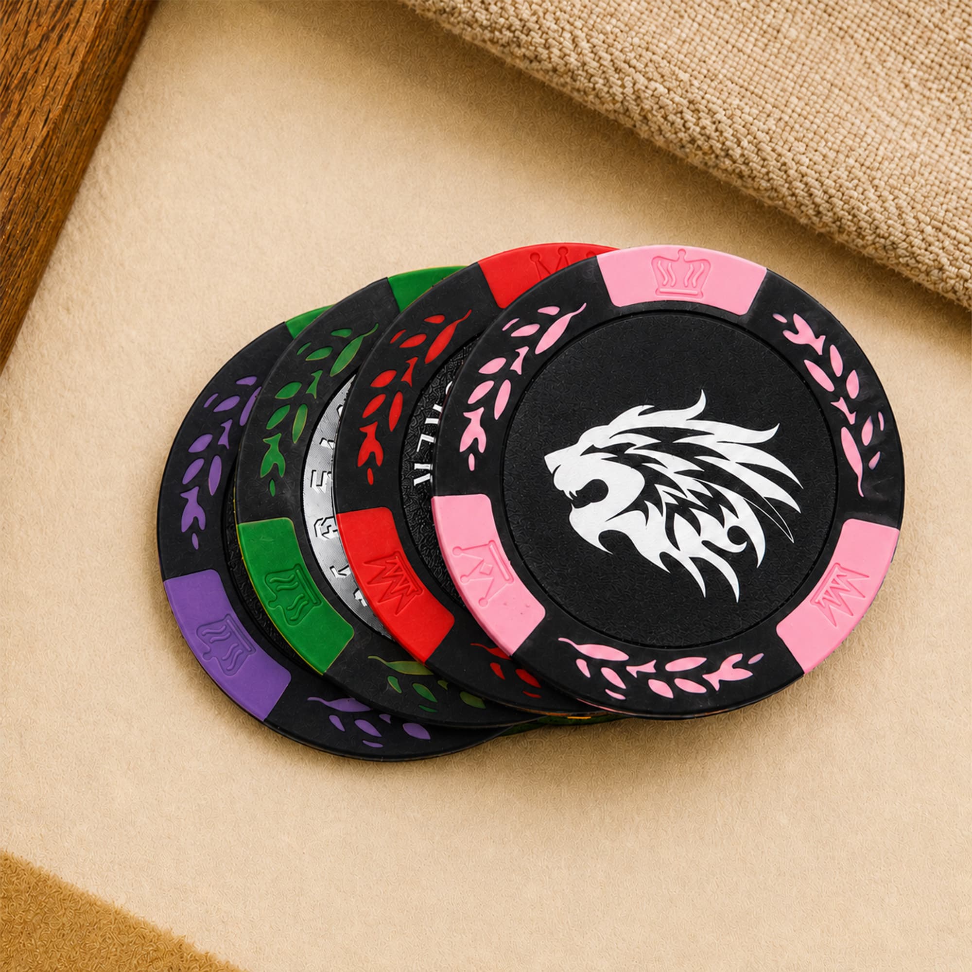 A set of black poker chips with colourful accents in green, purple, pink, and a lion logo in the centre.