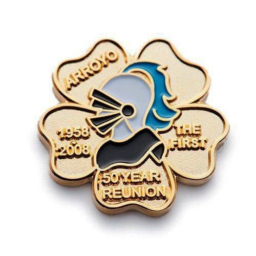 A gold embossed soft enamel pin featuring a stylised profile, set in a flower shape with inscriptions.