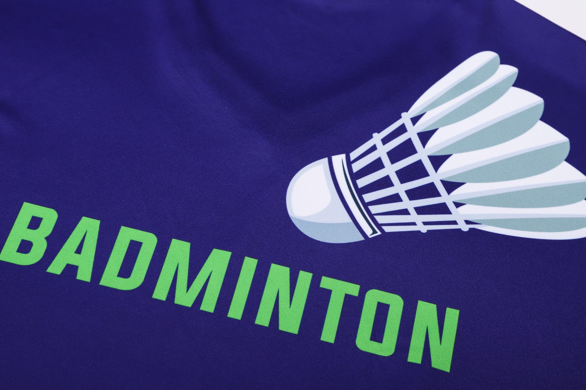 A purple long-sleeve V-neck shirt featuring a badminton shuttlecock design and the word "BADMINTON" in green.