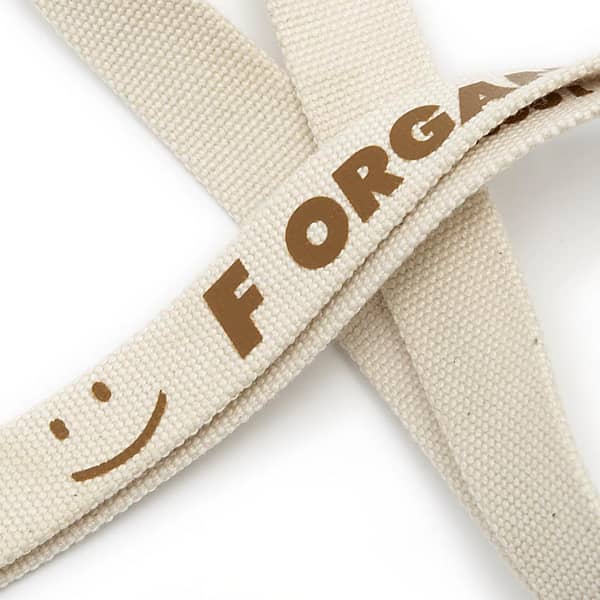 A cotton lanyard in a light beige colour with a logo, featuring a smiley face design.
