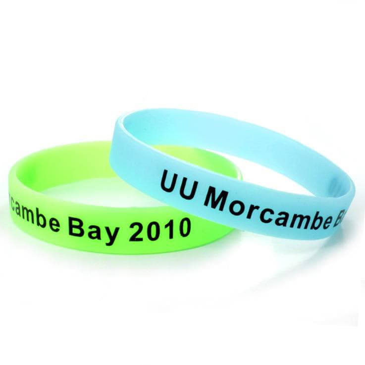 A set of glow-in-the-dark silicon wristbands in green and blue, featuring a logo and text.