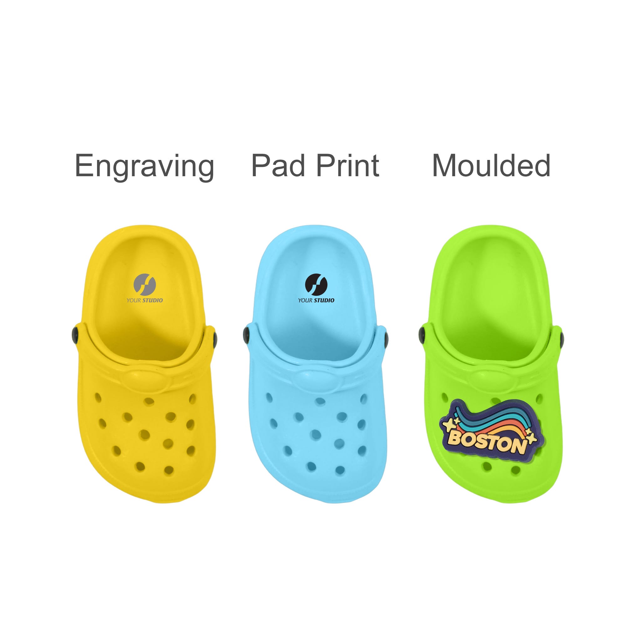 Three shoe-shaped charms in yellow, blue, and green, featuring various designs and a logo on the green charm.