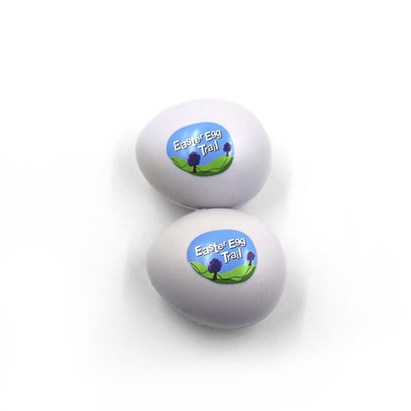 Two white egg-shaped stress relievers with a logo featuring a scenic design.