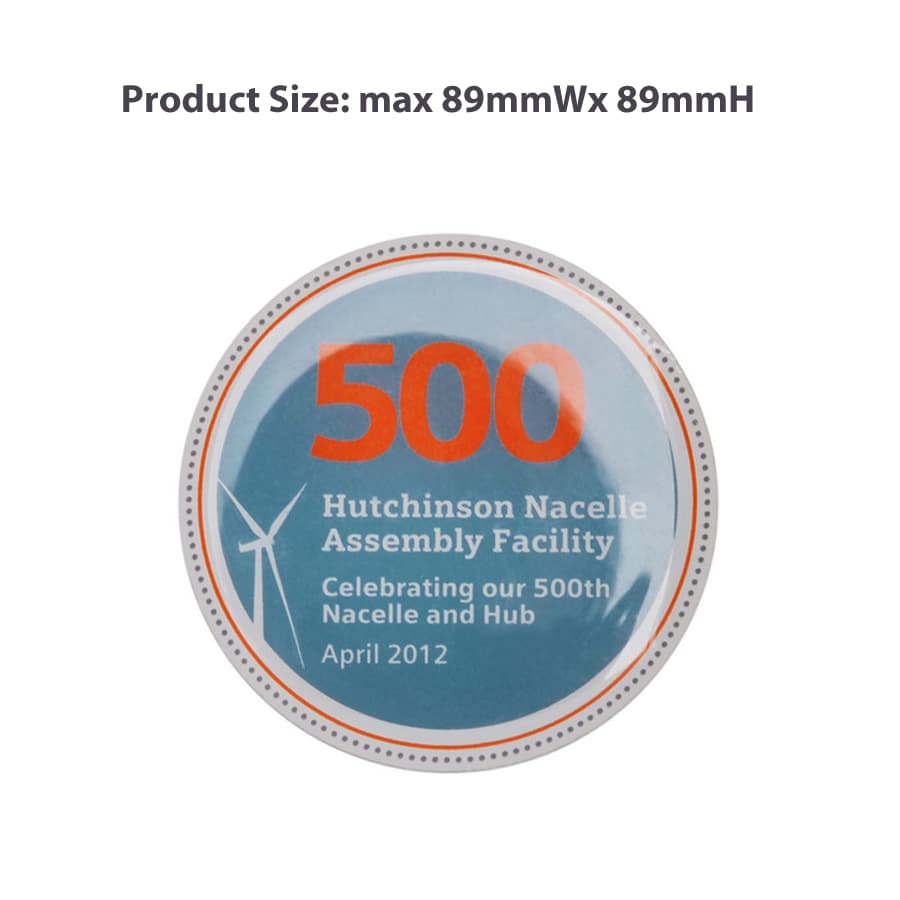 A circular promotional pin featuring a blue background with the number "500" in orange, and a logo.