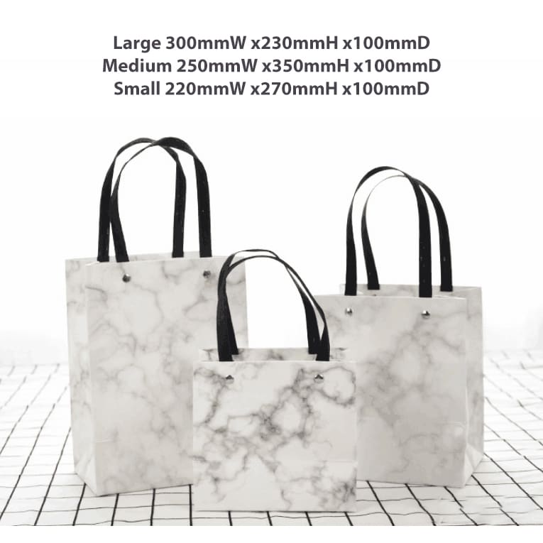 A set of three marble-patterned bags with black handles in varying sizes: large, medium, and small.