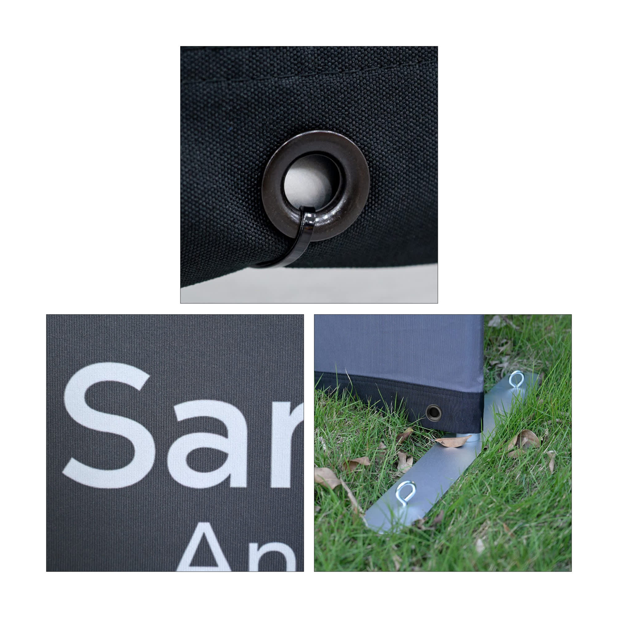 Close-up of a black Sidewalk Cafe Barrier featuring a grommet, a logo, and a base anchor on grass.