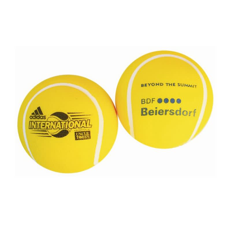 A yellow tennis-shaped stress reliever with branding on both sides. Features a textured surface resembling a tennis ball.