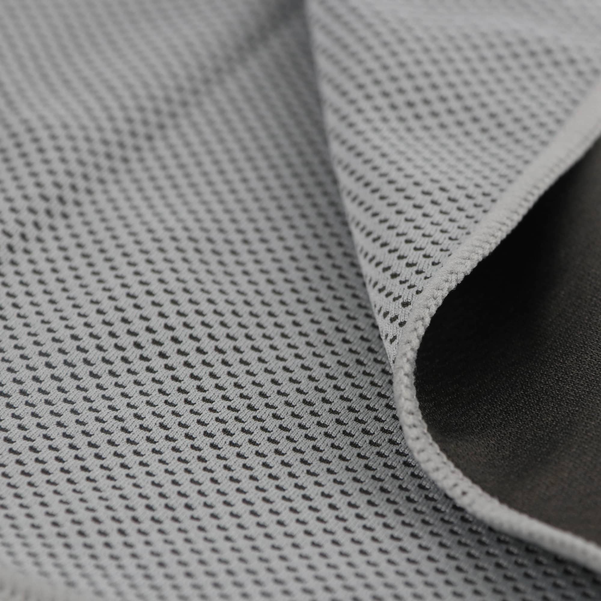 A cooling towel featuring a grey perforated design with a contrasting dark edge, ideal for outdoor activities.