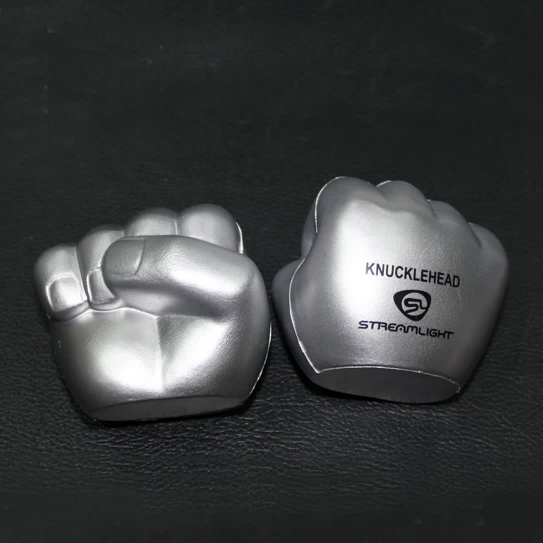 Clenched fist-shaped stress relievers in silver, featuring a logo on one side.
