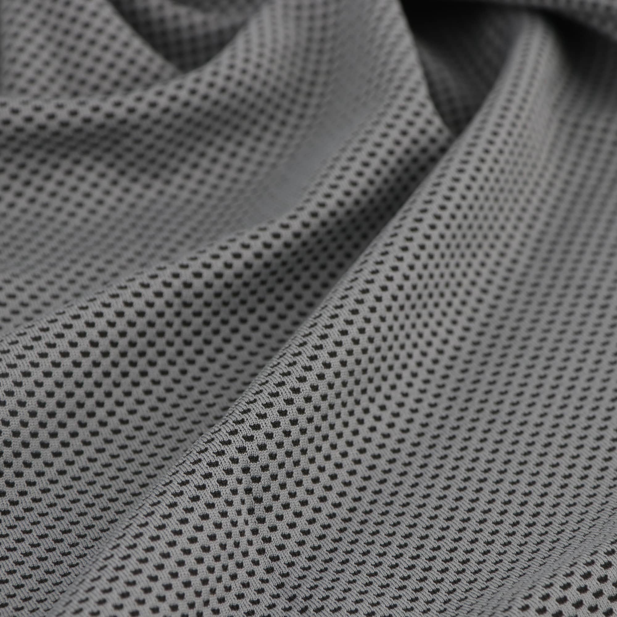 A cooling towel in a textured grey fabric with a breathable design. It features a logo.