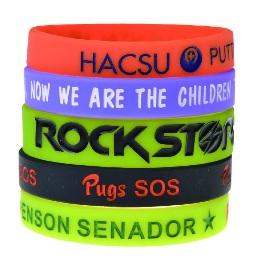 A set of debossed silicone wristbands in red, green, purple, blue, and black, featuring various logos and text.