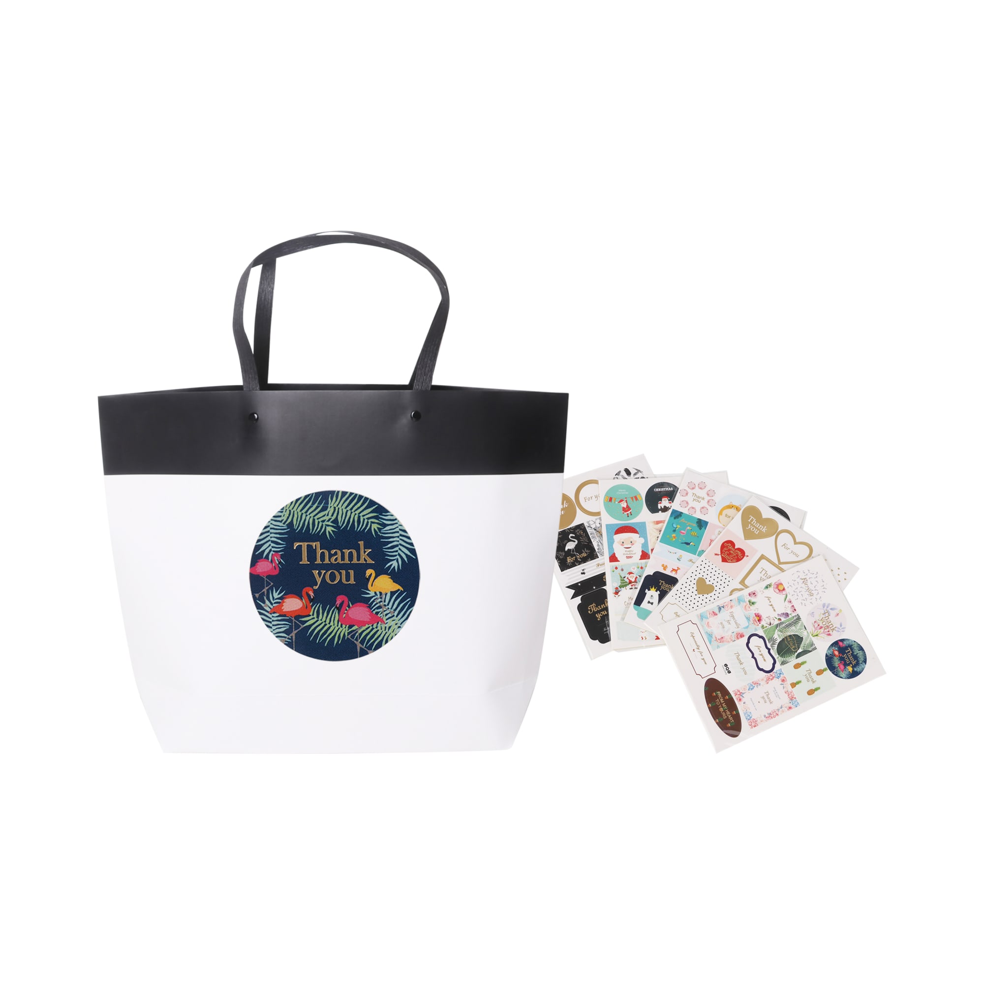 A medium black and white boutique paper bag with black handles, accompanied by various decorative stickers.