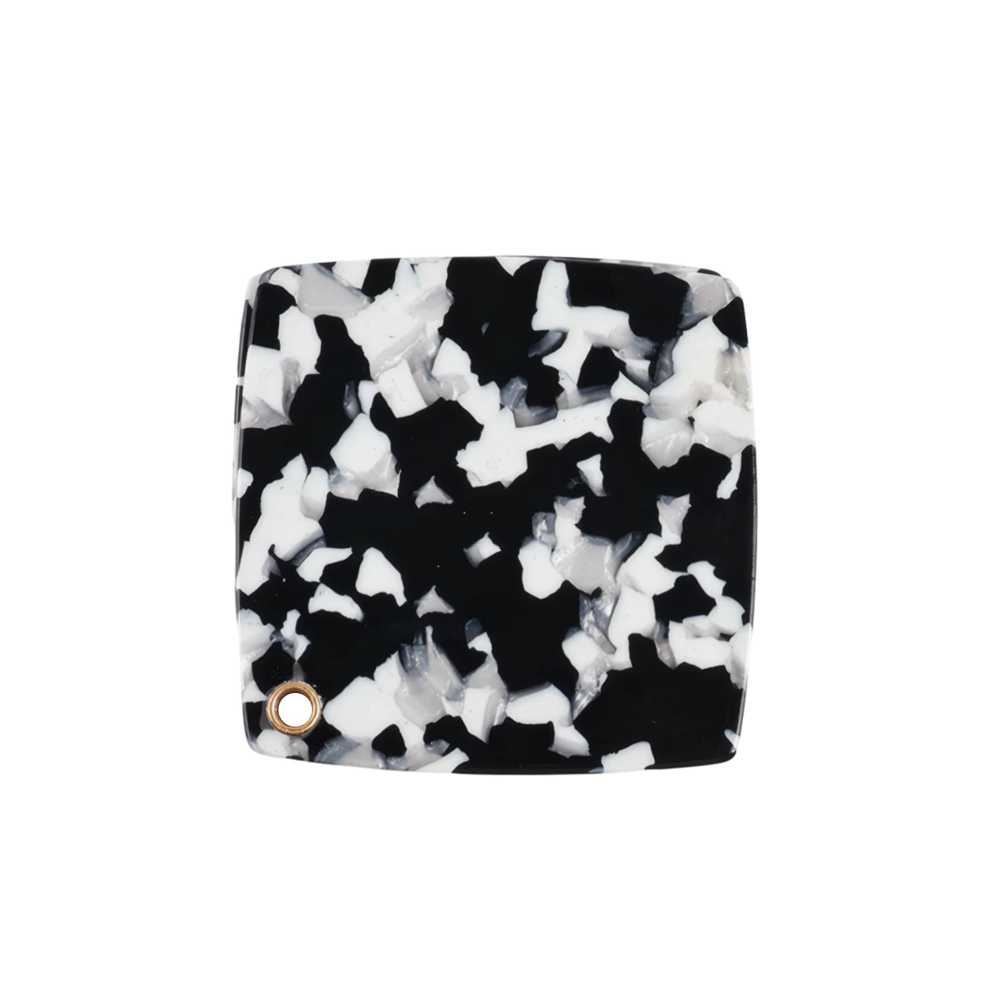A square acetate vanity mirror featuring a black and white speckled design with a small gold accent.