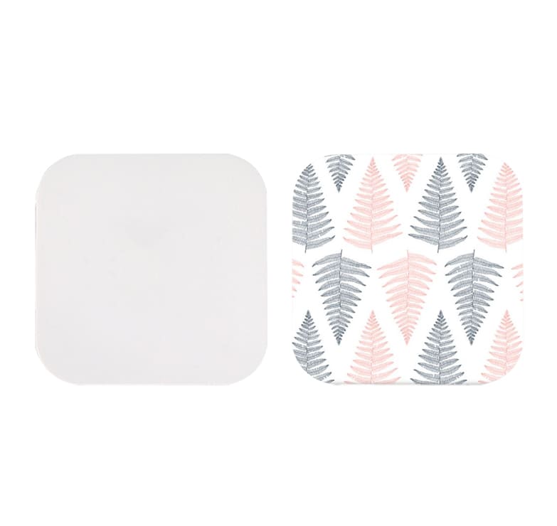 A square-shaped wireless charger with a plain white side and a patterned side featuring pink and grey fern leaves.
