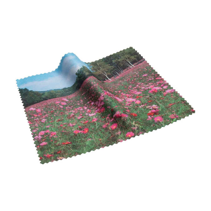 A microfibre lens cloth featuring a vibrant landscape of pink flowers against a green backdrop. The cloth has a branded logo.