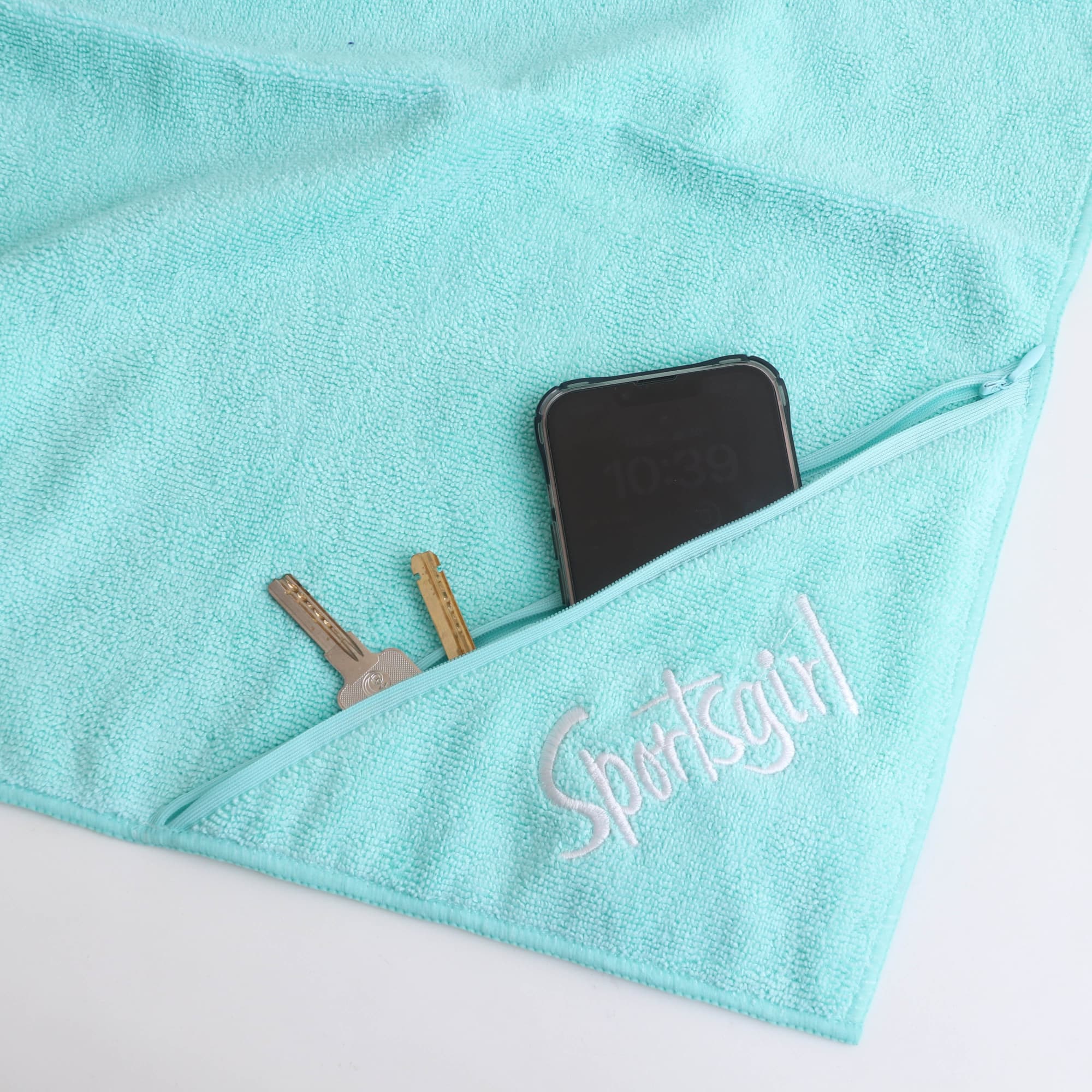 A light blue embroidery sport towel with a zip pocket, featuring a phone, keys, and a measuring tape.