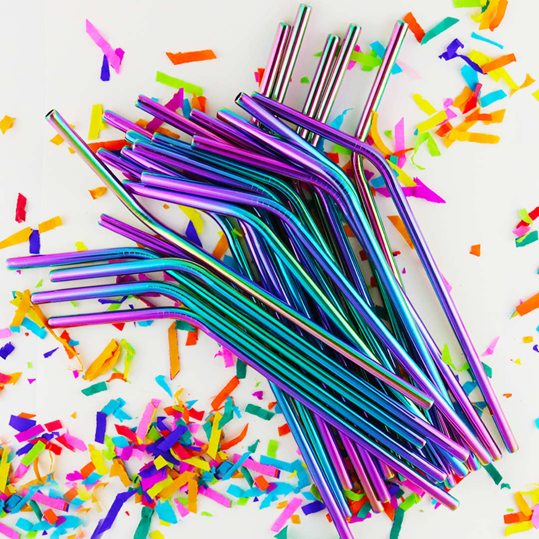 A group of multicoloured stainless steel straws with a shiny finish, surrounded by colourful confetti.