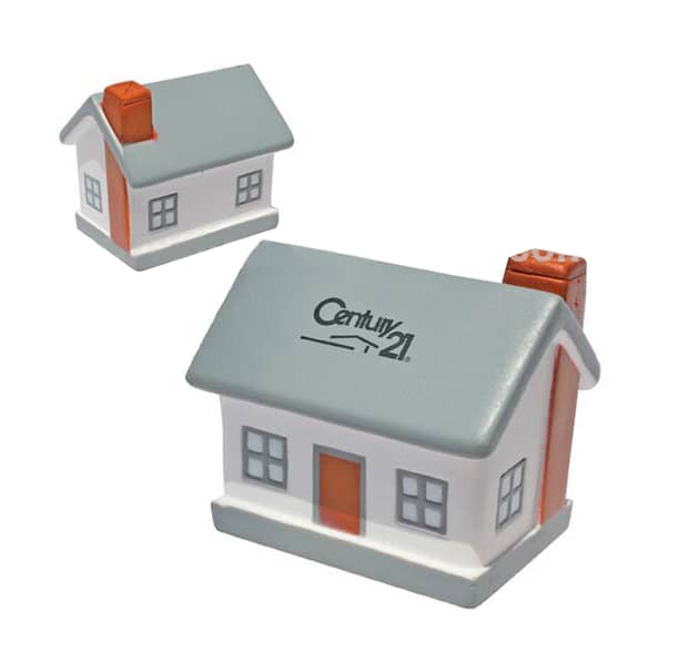 A house-shaped stress reliever in grey, white, and orange, featuring a chimney and a logo on the front.