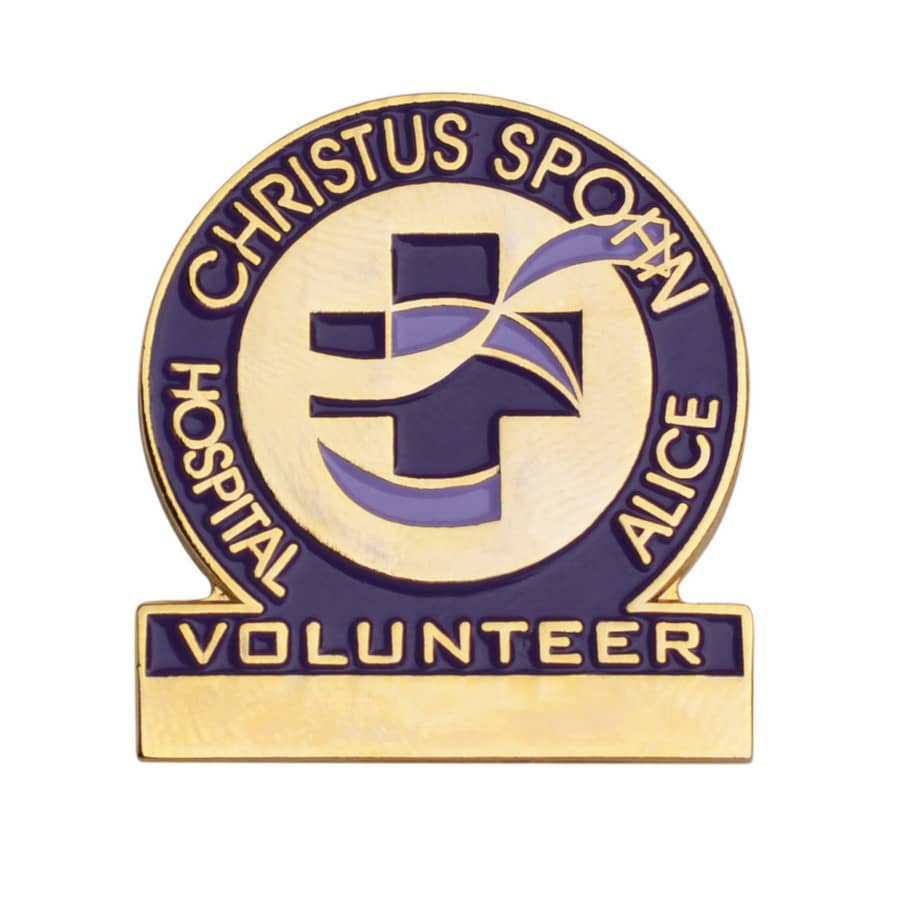 A gold and blue enamel lapel pin with a cross design and the word "VOLUNTEER" at the base.