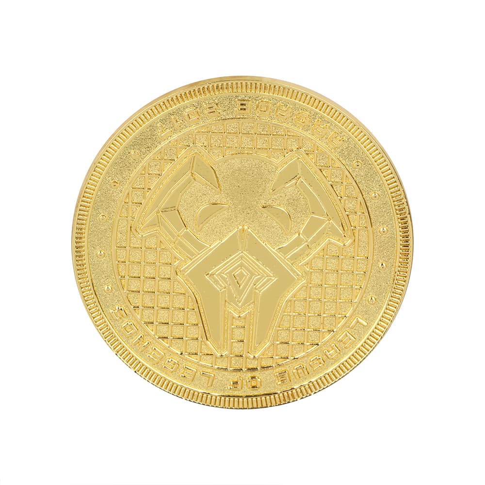 A gold coin pin featuring a textured surface and intricate design. The pin has a logo on it.