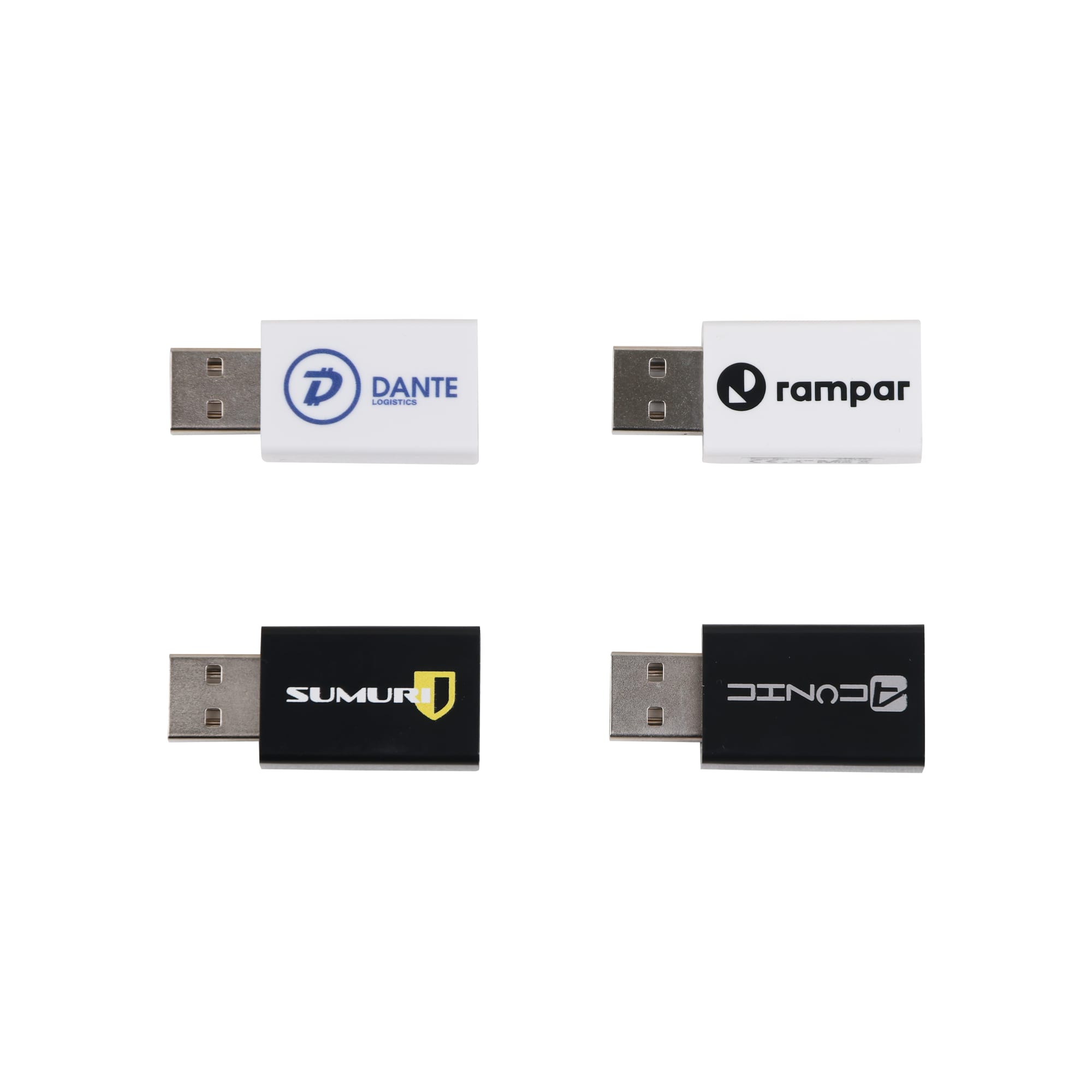 Four USB data blockers in white and black with various logos. They feature standard USB connectors.
