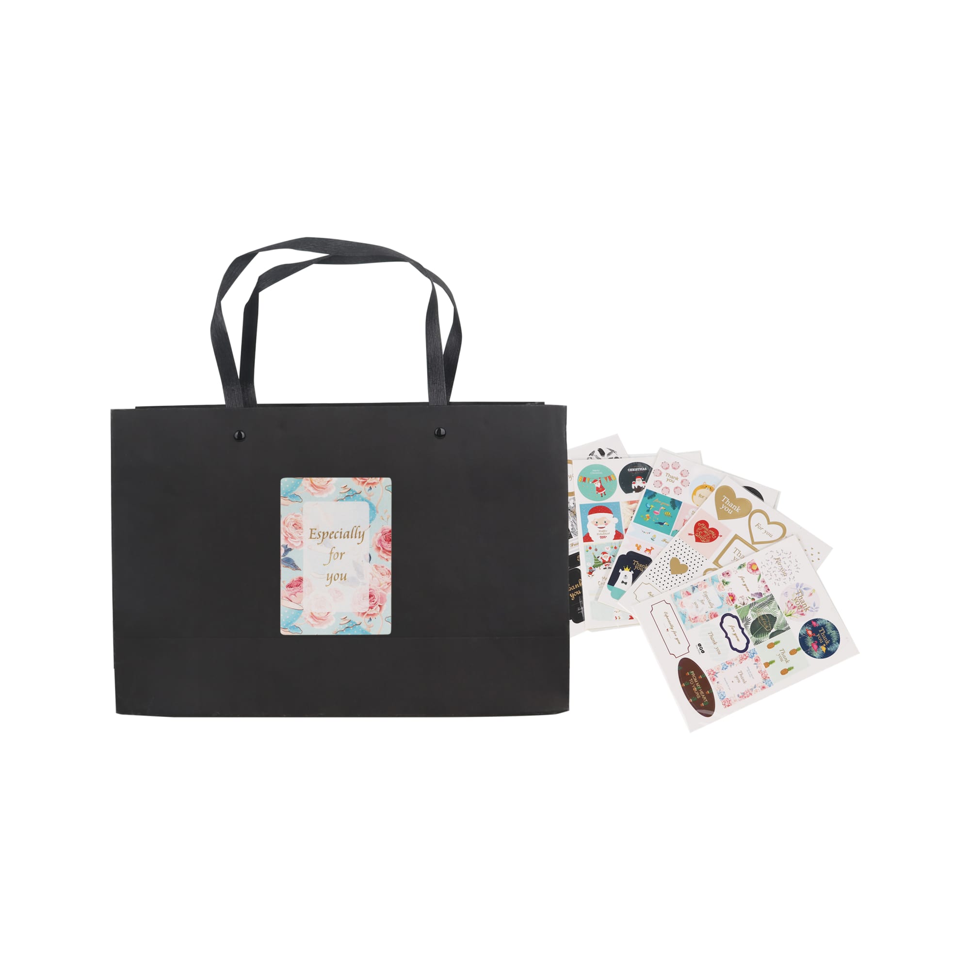 A black paper bag with a knitted handle and a decorative label, accompanied by assorted stickers.