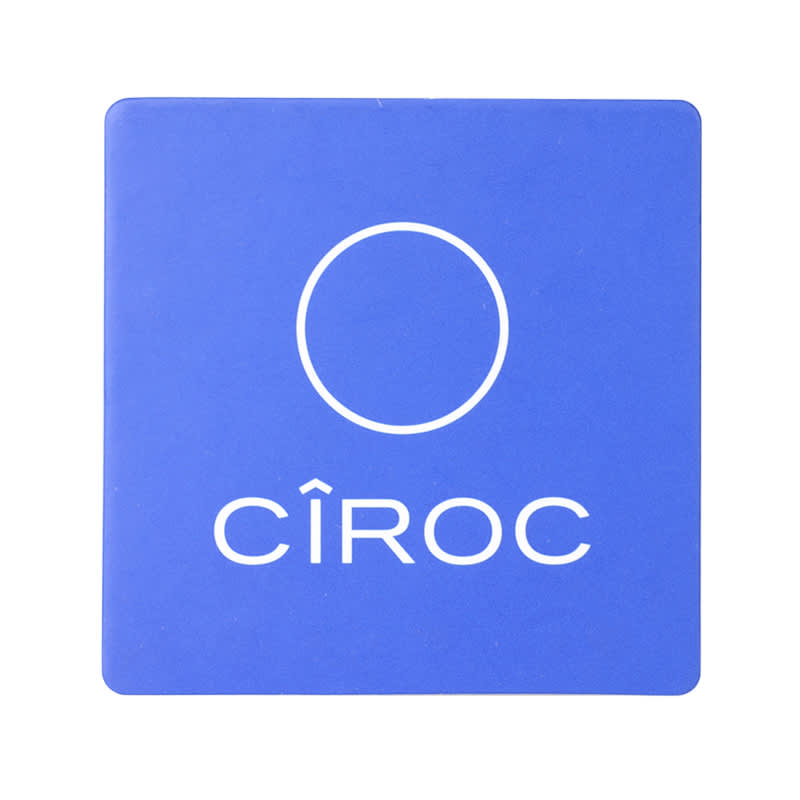 A blue cork coaster with a circular logo and branding.