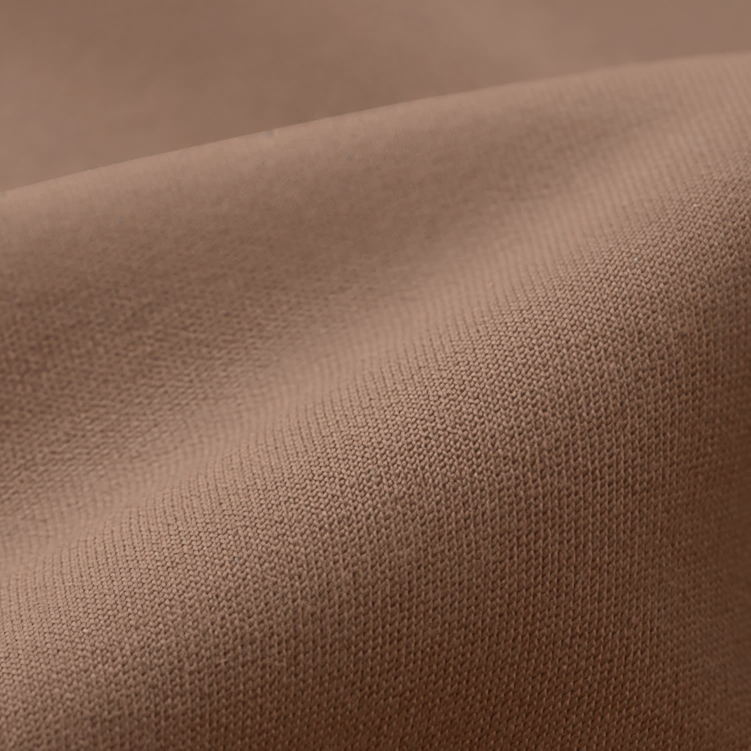 A close-up of smooth, elastic fabric in a warm brown colour, featuring fine weave texture.