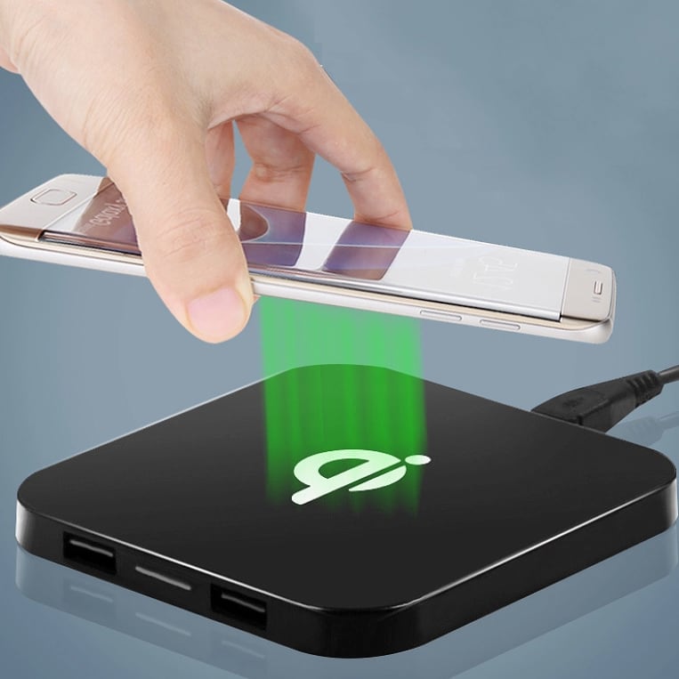 A black square wireless charger with a logo, featuring a hand placing a phone on it.
