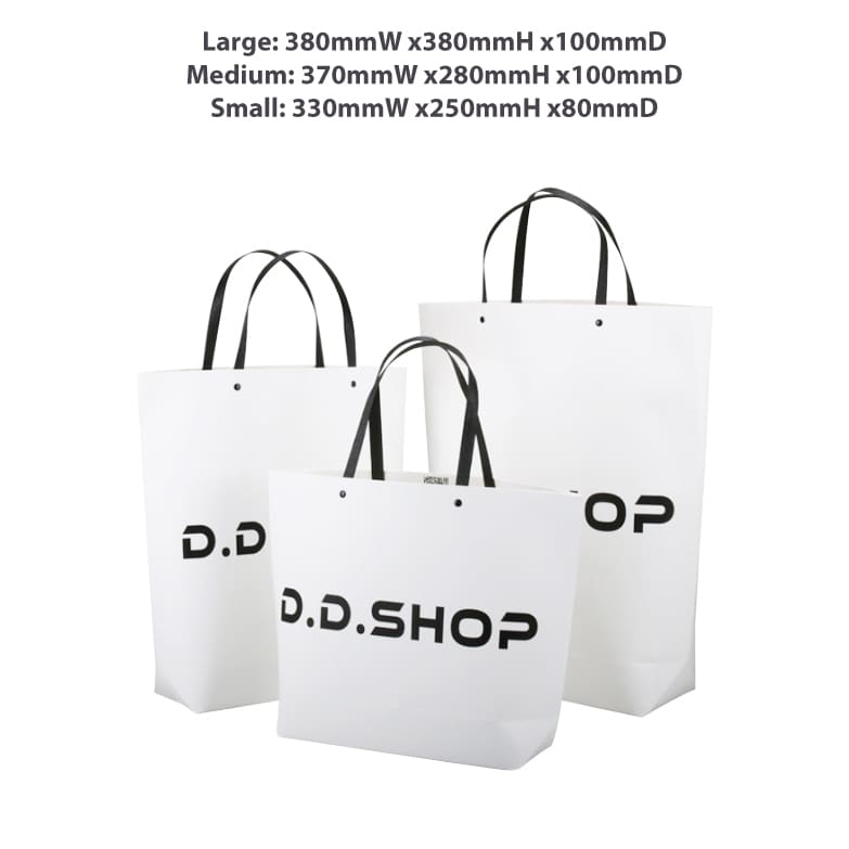 Three white paper bags of varying sizes with black handles, featuring a logo on each. The medium bag measures 370 x 280 x 100mm.