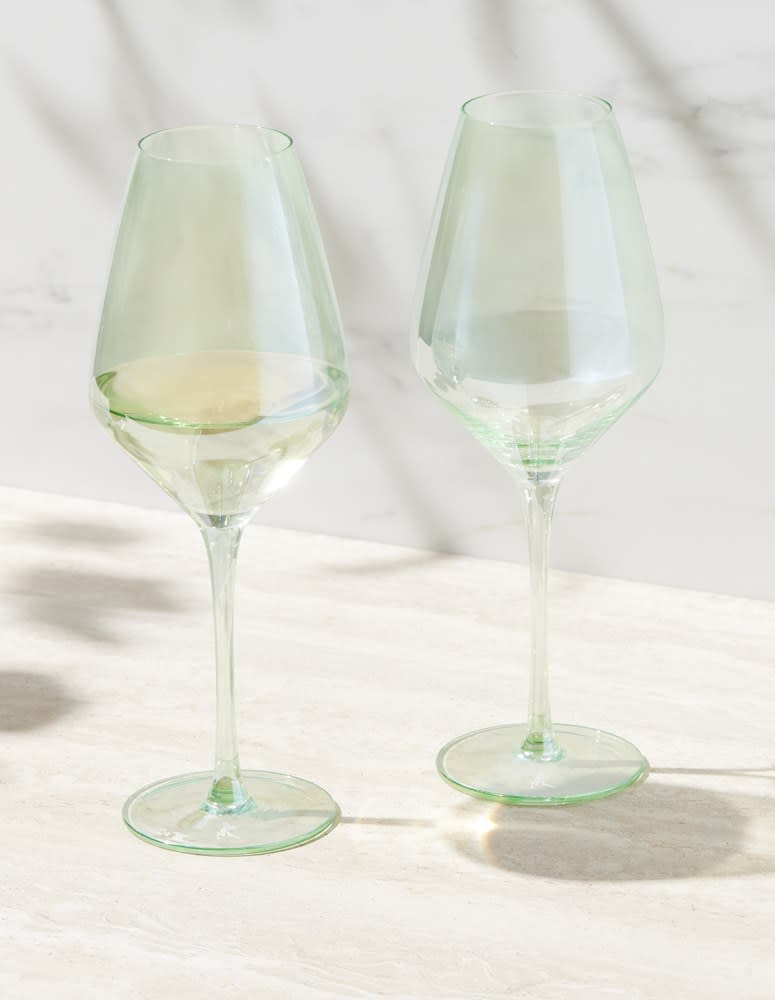 A set of two green-tinted wine glasses displayed on a light surface, featuring a sleek design and stem.