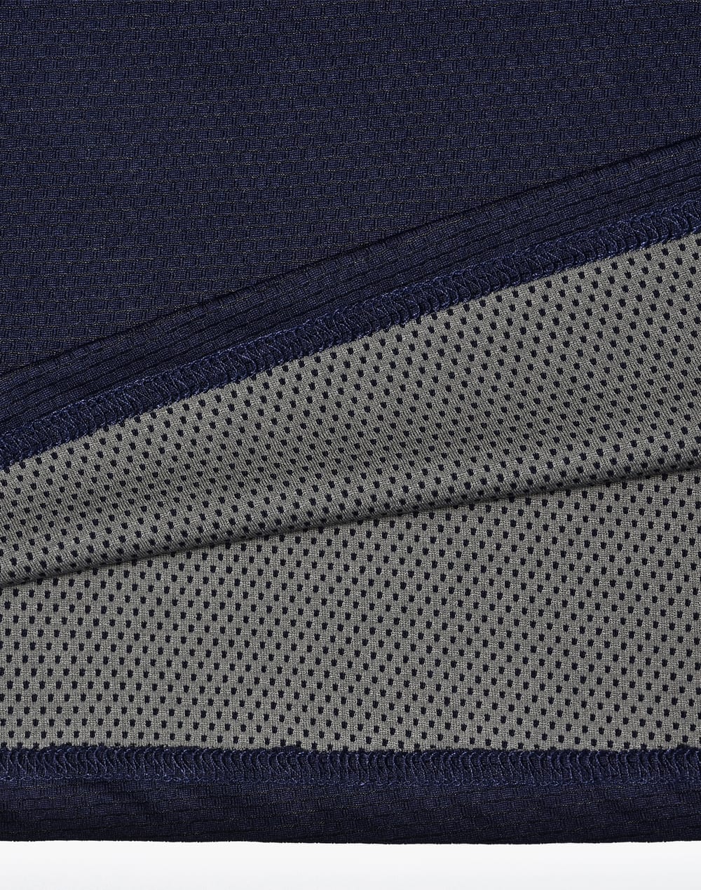 A close-up of a navy polo shirt detailing with a grey mesh inner lining, featuring a logo.