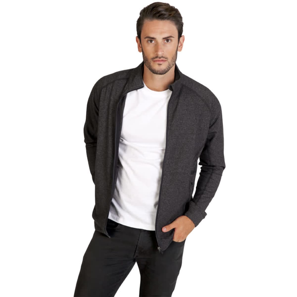 A man wearing a charcoal grey zip-up jacket over a white t-shirt, posing with hands in pockets. The jacket has a logo.