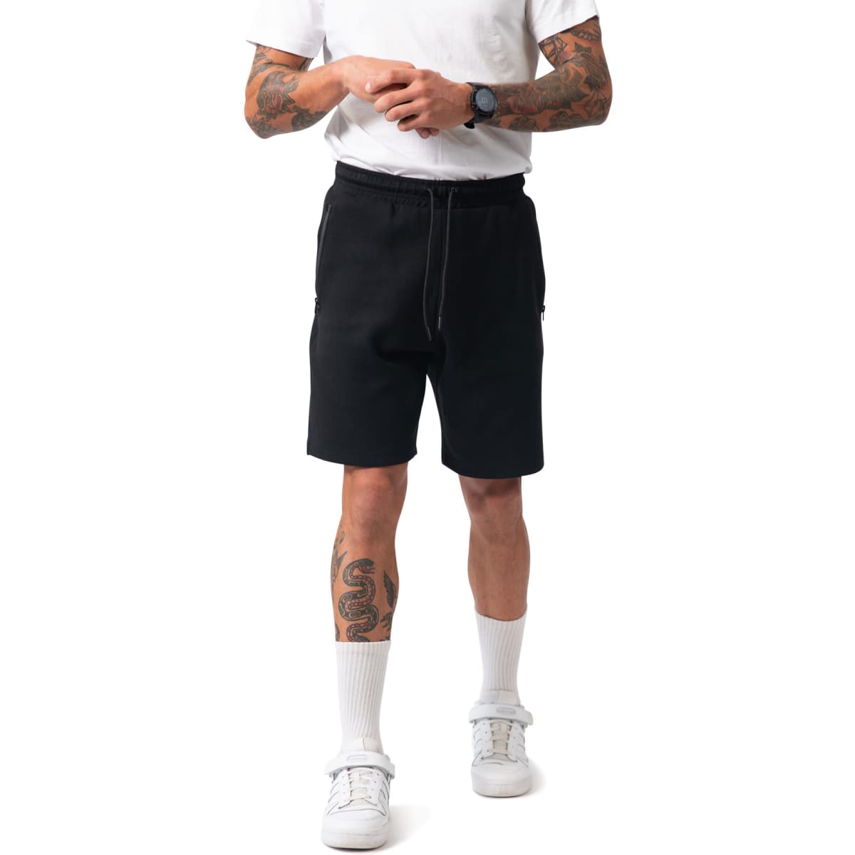 Black men's cotton sandwich shorts with an elastic waistband and side pockets, modelled by a person with tattoos.