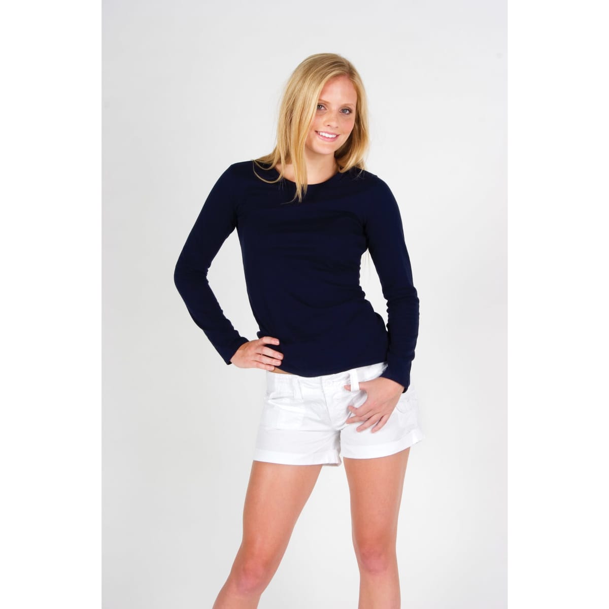 A model wearing a navy long sleeve T-shirt paired with white shorts, featuring a simple design and a logo.