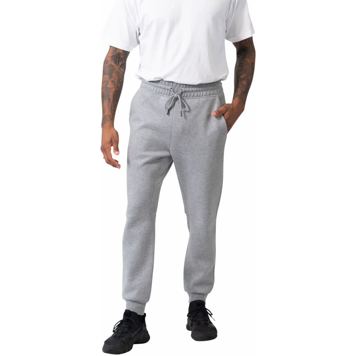 A person wearing grey men's three-layer cotton sandwich pants, featuring an elastic waistband and side pockets.