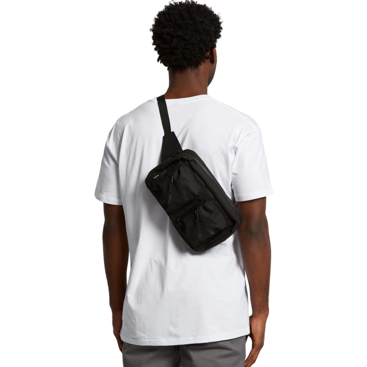 A black recycled double waist bag worn across the back of a person in a white T-shirt. The bag features a logo.