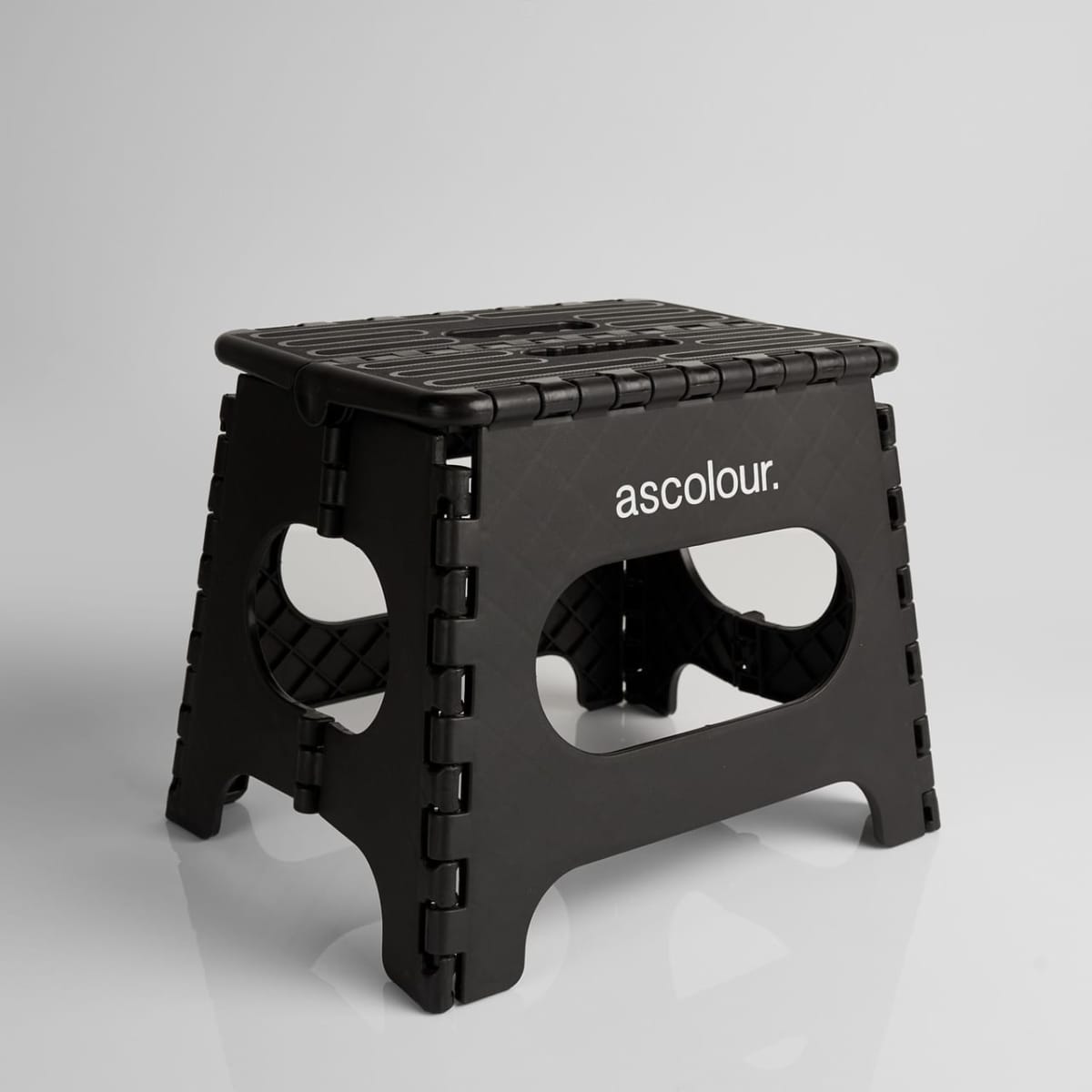A black ASC Utility Stool with a textured surface and cut-out handles, featuring a logo on one side.