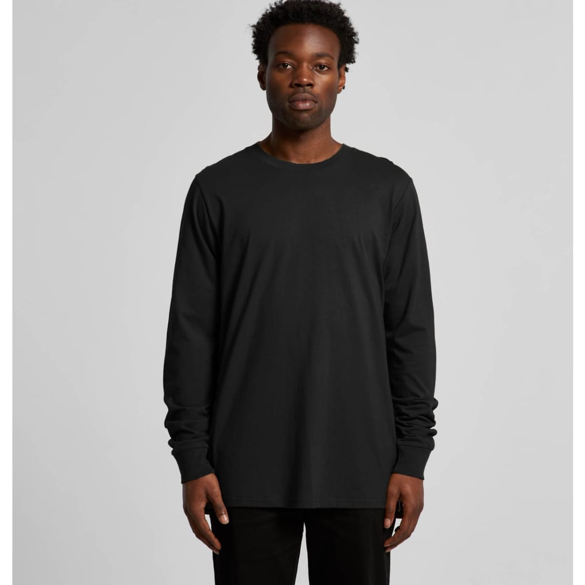 A long-sleeve black T-shirt displayed on a model, featuring a simple design and a logo.